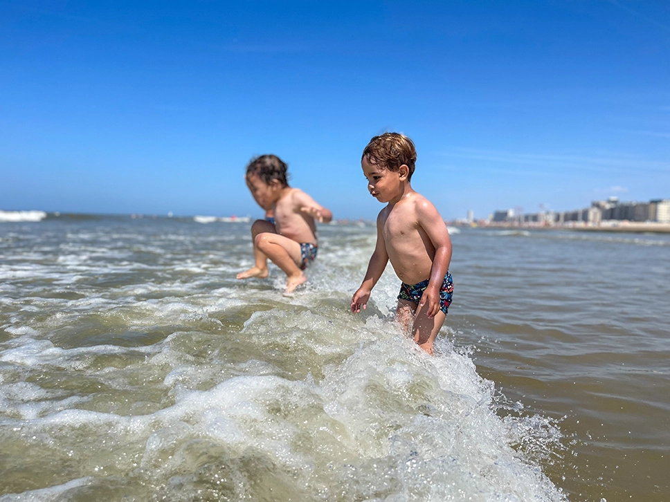 niños jugando con las olas
